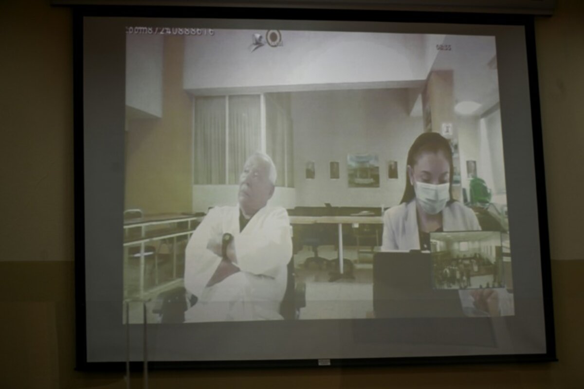 O general reformado Benedicto Lucas García (91) aparece em um telão durante uma videochamada de sua audiência, do quarto de um hospital militar onde está detido na Cidade da Guatemala, em 5 de abril de 2024 - AFP